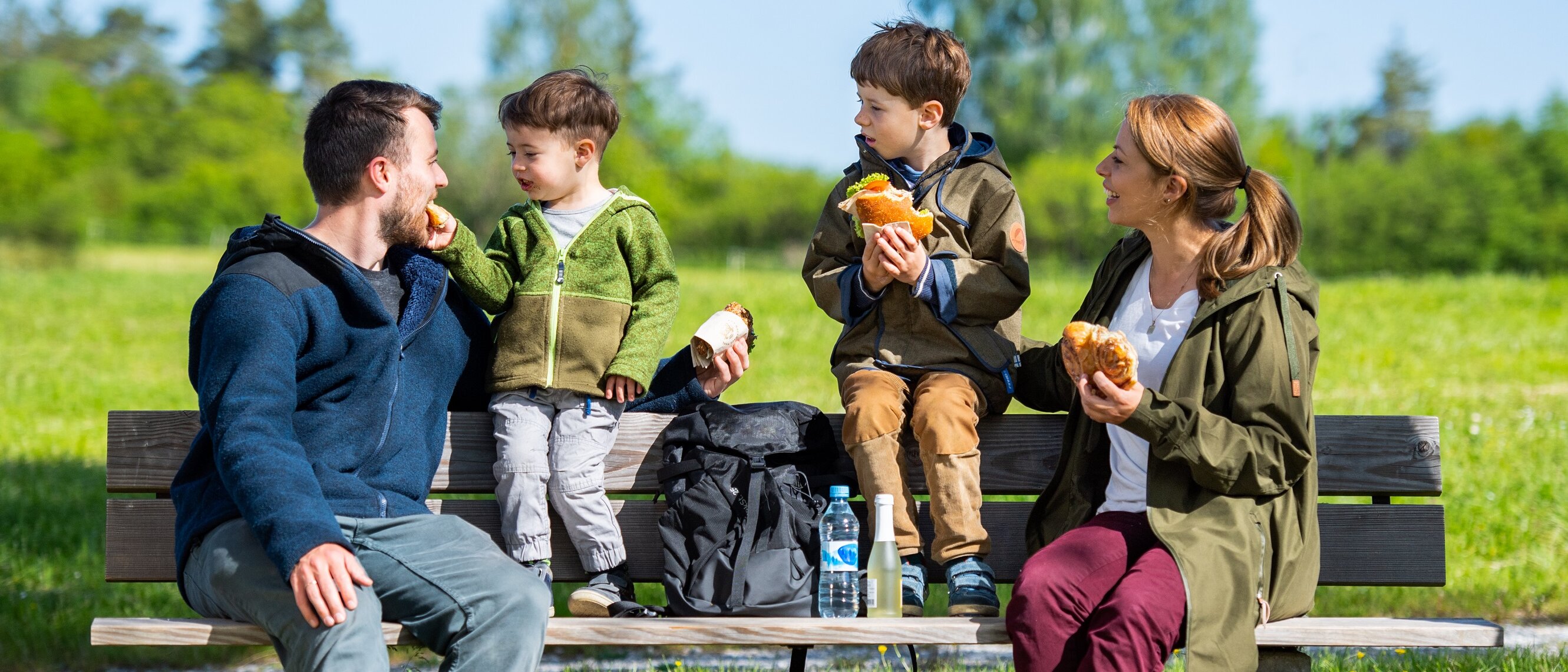 Familie macht Vesperpause auf Holzbank
