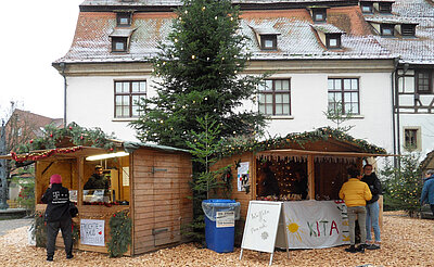Zwei Holzhäuschen vor der Zehntscheuer bei der Waldweihnacht