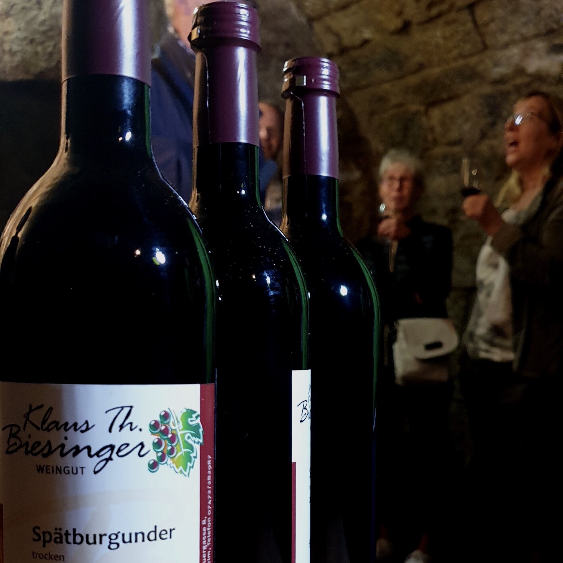 Drei Weinflaschen in einem Gewölbekeller
