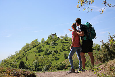 Wanderer zeigen auf die Wurmlinger Kapelle