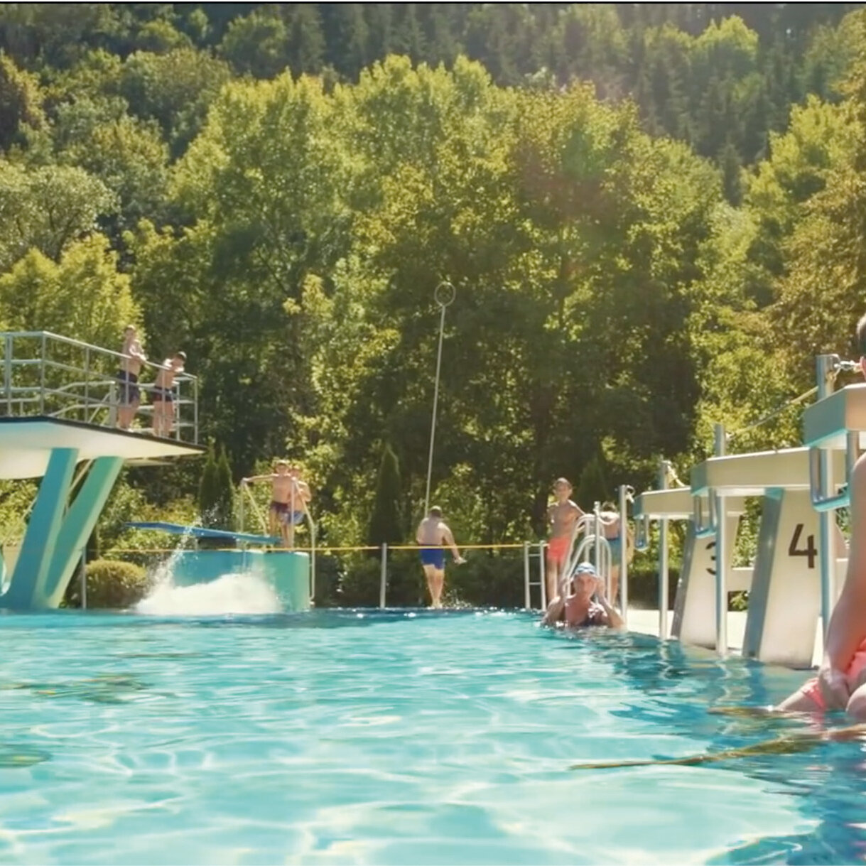 Zwei junge Männer am Beckenrand im Freibad