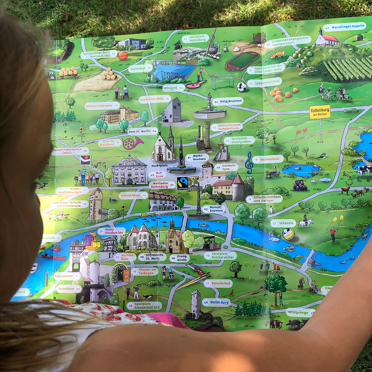 Kind schaut sich den Kinderstadtplan an