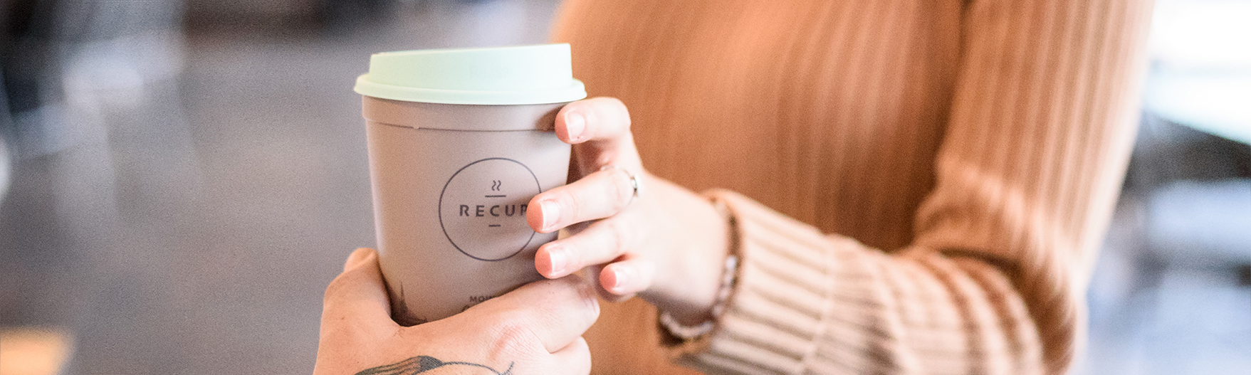 Jemand hält ReCup Pfandbecher in der Hand
