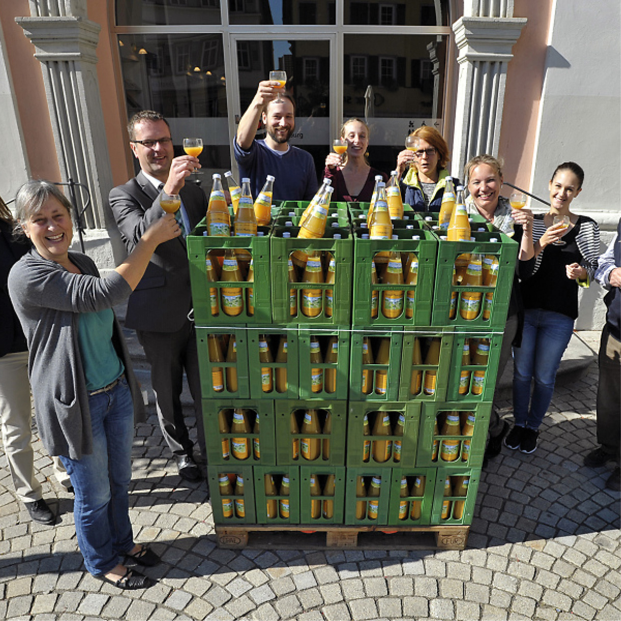 Saftkisten und Menschen die Gläser heben