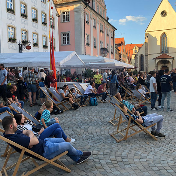 Menschen in Liegestühlen auf dem Marktplatz