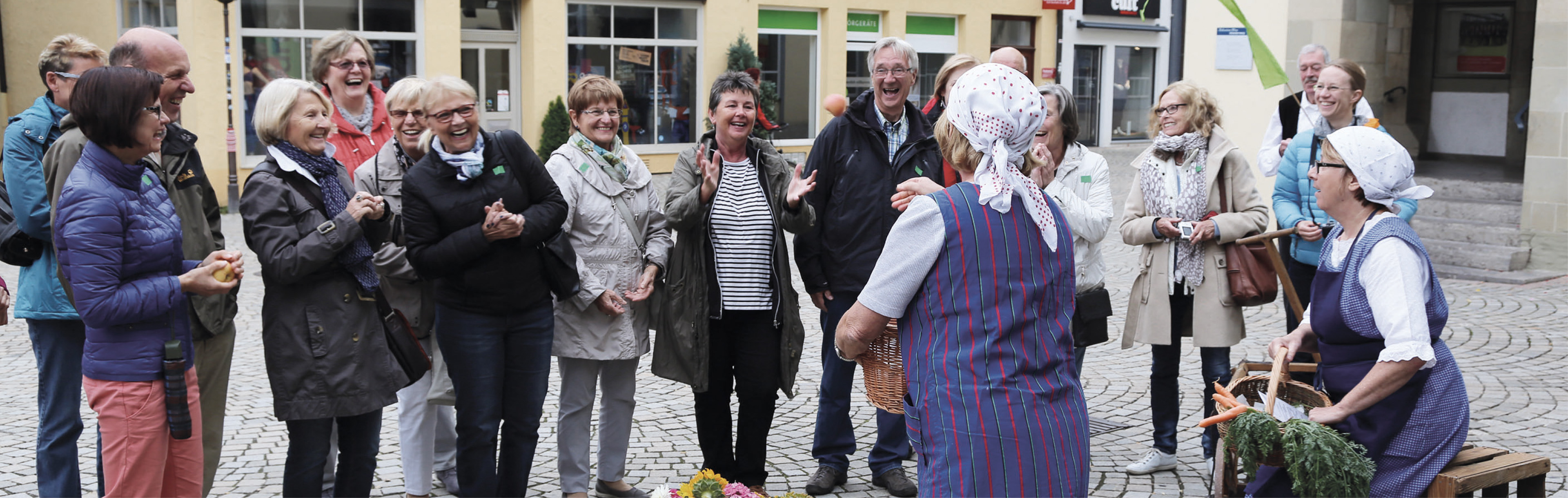 Stadtführerinnen und Gruppe lachender Menschen
