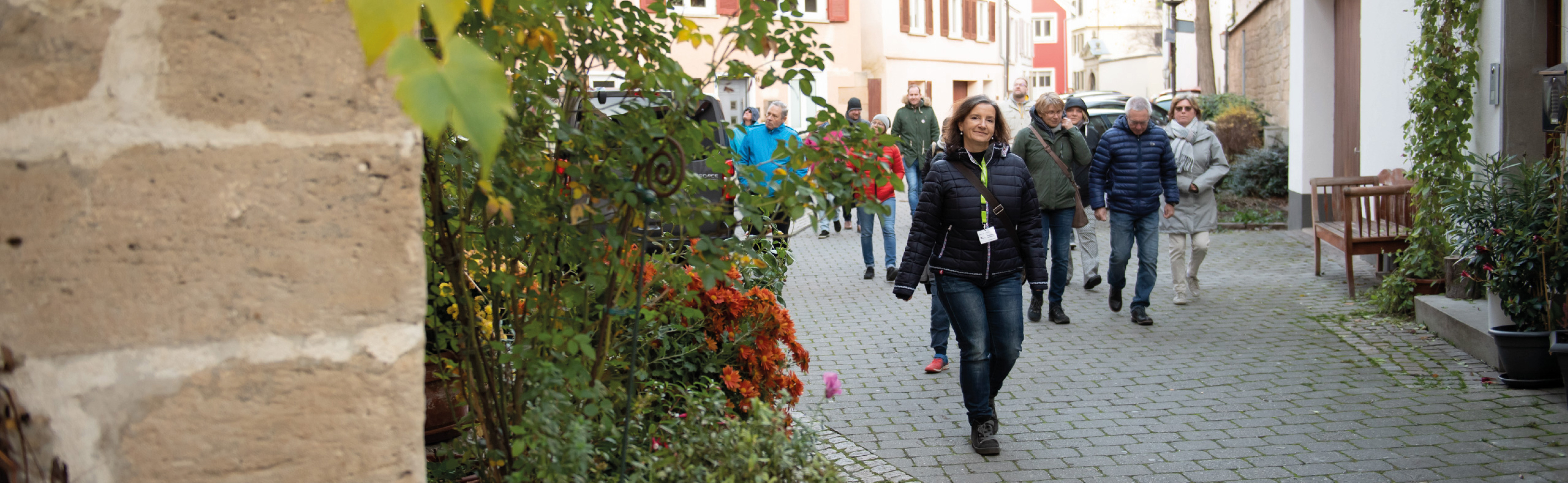 Stadtführerin läuft vor Gruppe durch eine Gasse